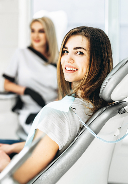 Woman in the dental chair smiling back over her shoulder