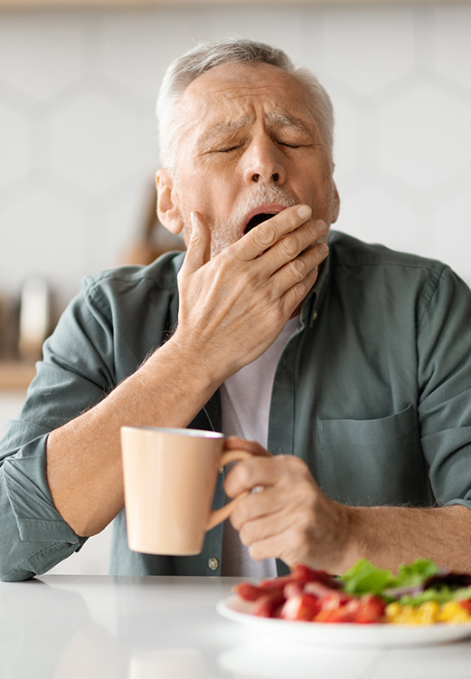 Senior man yawning before sleep apnea treatment in Madison