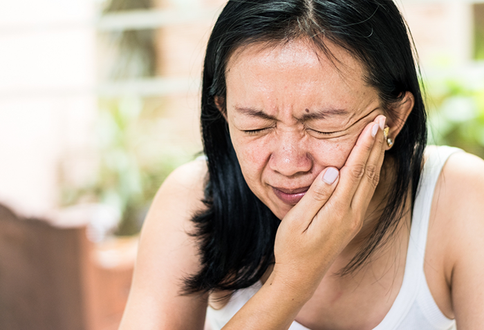 Woman holding the side of her jaw in pain