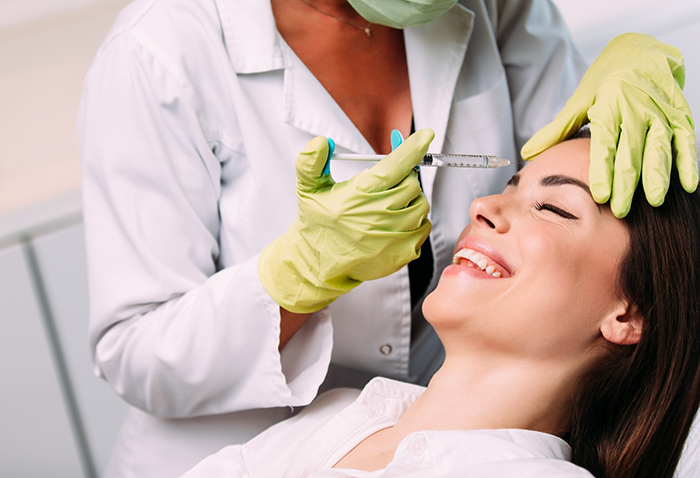 Dental patient receiving an injection in her forehead