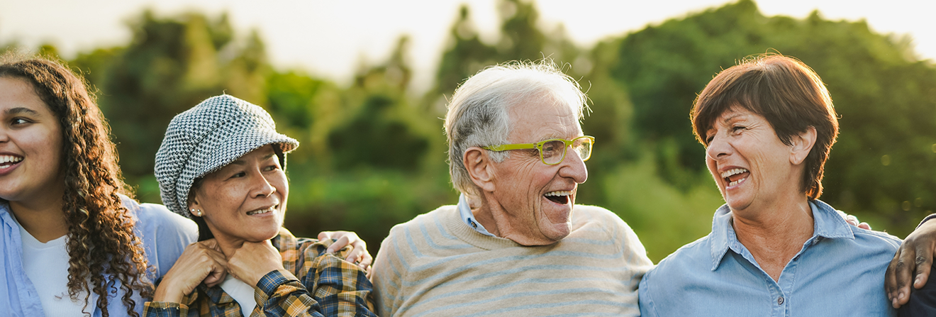 Group of older adults laughing together outside after receiving dental services in Madison