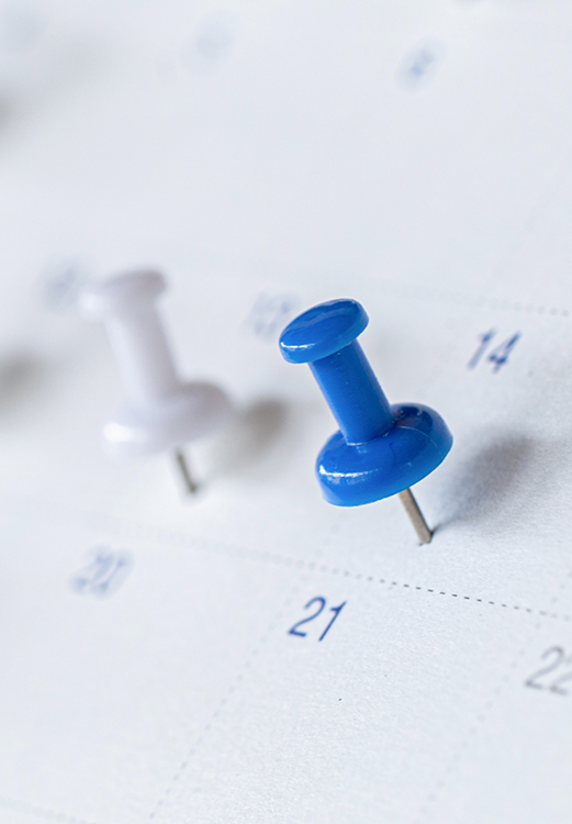 Date of a dental appointment marked on a calendar with a push pin